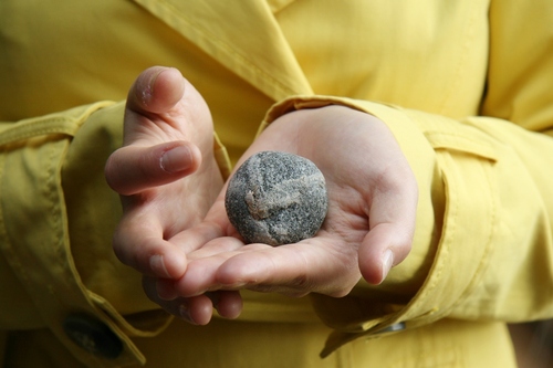 Lapsi pitelee kiveä.